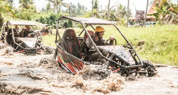 UTV buggy riders crossing a muddy track in Ubud, Bali